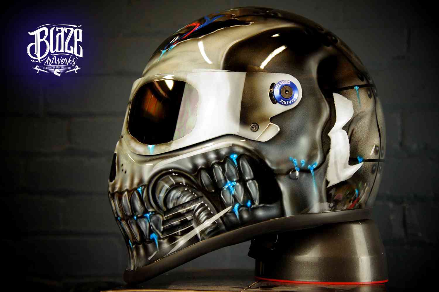Metallic silver robot skull helmet with chrome finish, blue LED-style glowing details, mechanical jaw design and futuristic cyborg styling