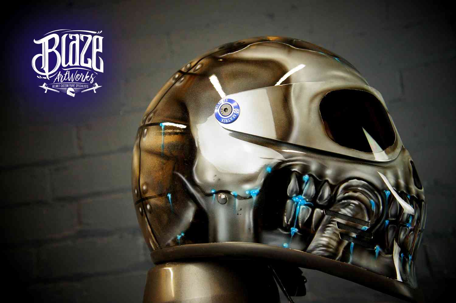 Chrome mechanical skull motorcycle helmet with metallic silver finish, blue accent lights, robotic jaw detail and futuristic design