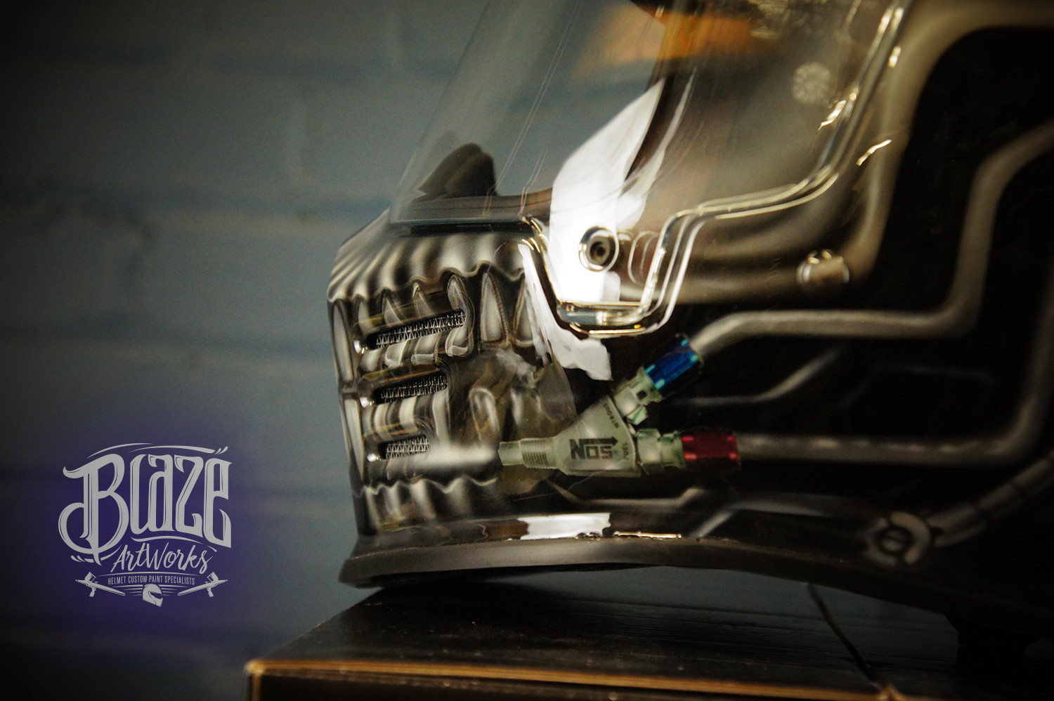 Detailed chrome skull design airbrushed on motorcycle helmet with metallic silver finish, realistic bone texture and jaw detail