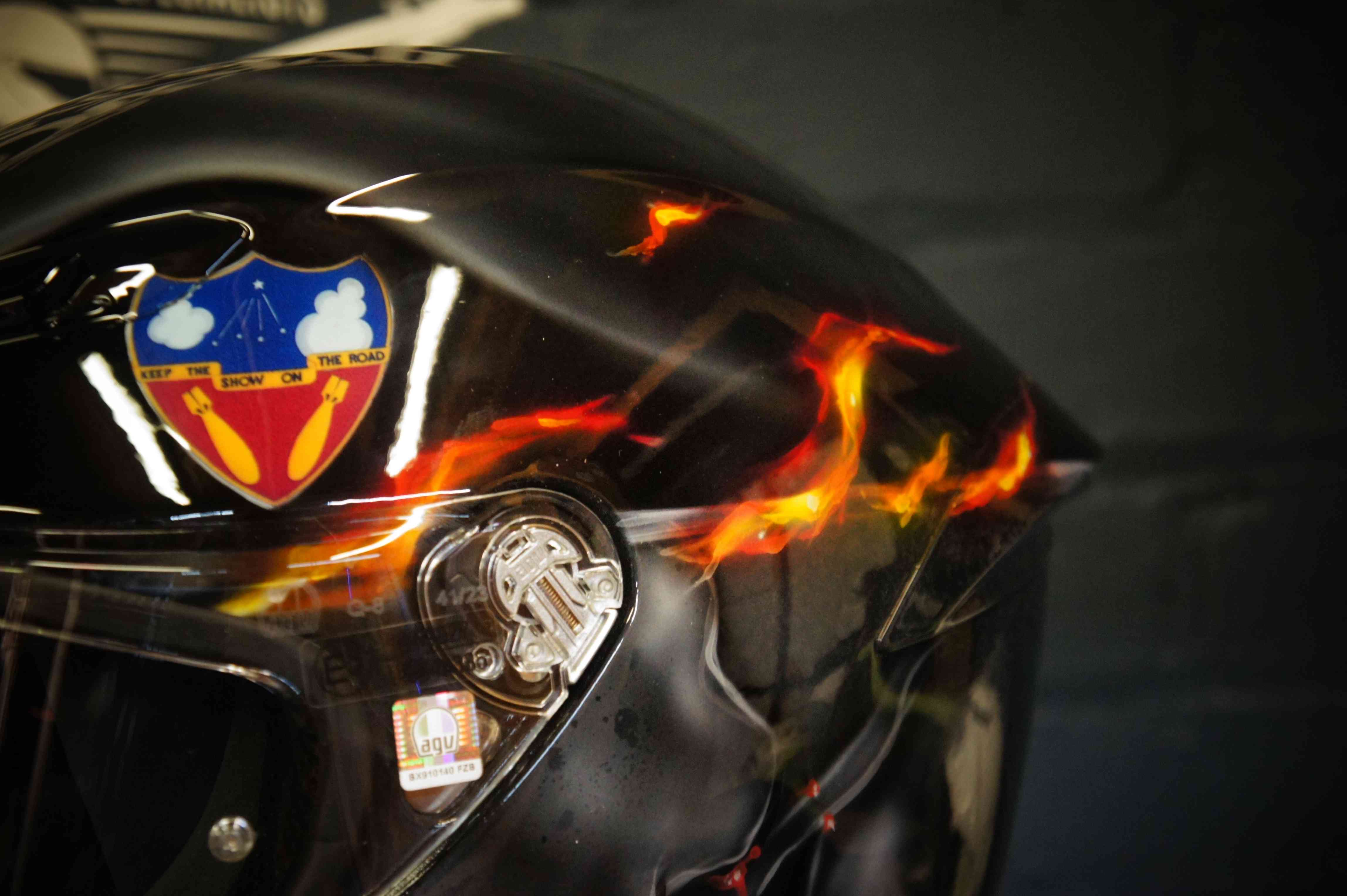 Black motorcycle helmet with realistic orange and red flame design, tribal flame pattern with candy finish and airbrush detail