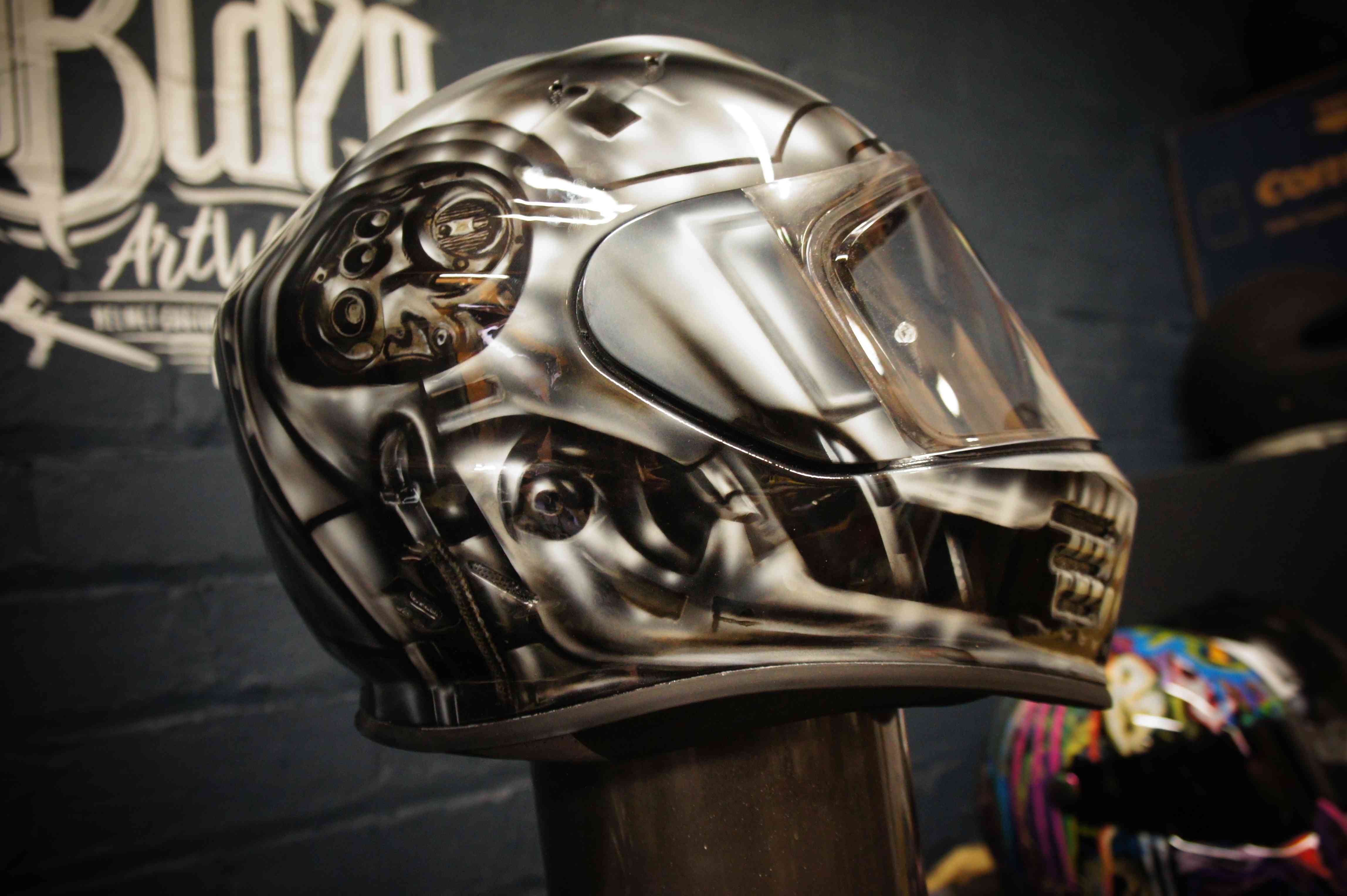 Chrome metallic skull motorcycle helmet with robotic endoskeleton jaw, glowing red eyes and hyper-realistic 3D airbrush effects