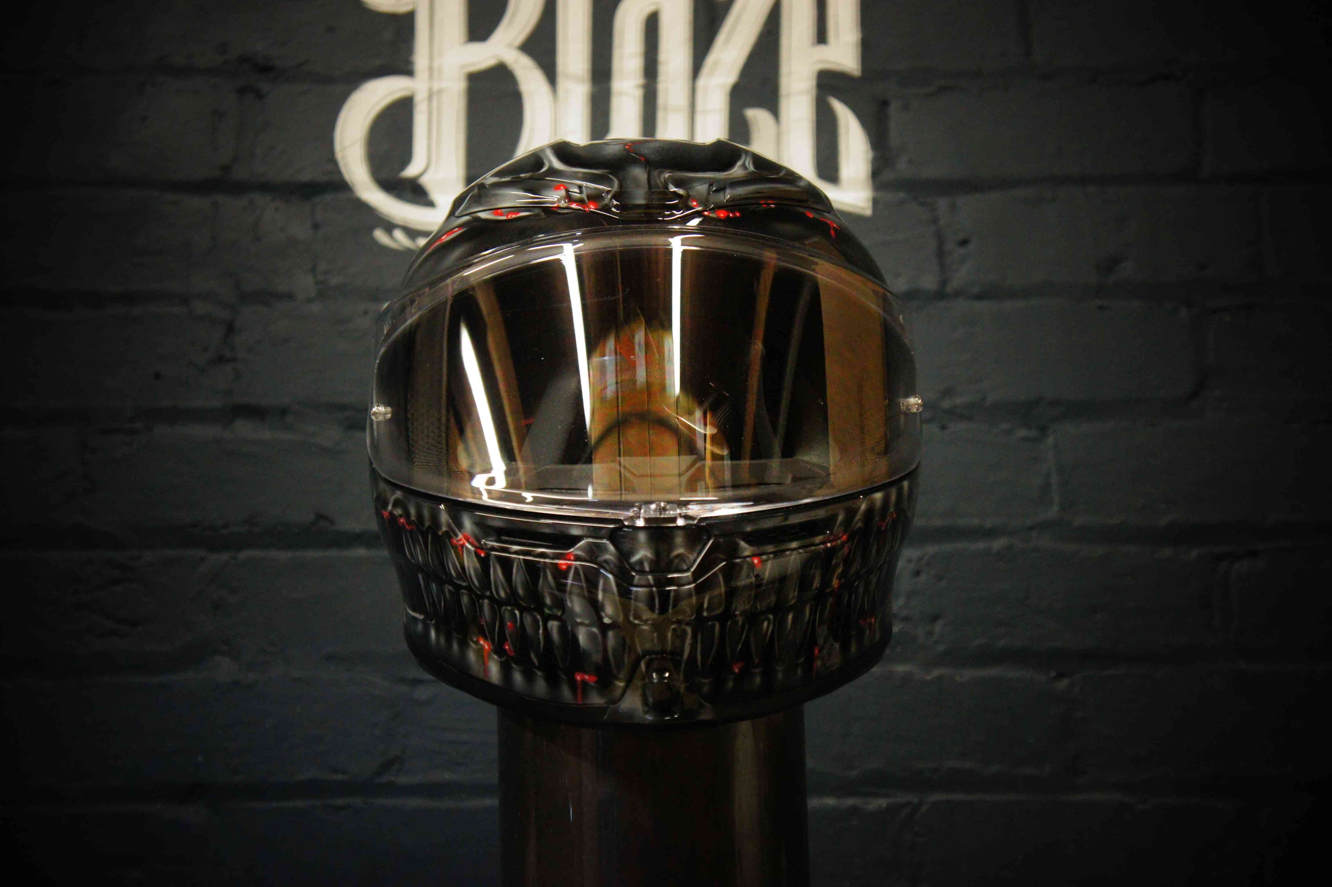 Black motorcycle helmet with detailed grey skull and skeleton jaw design, red accent details, glossy clear coat finish