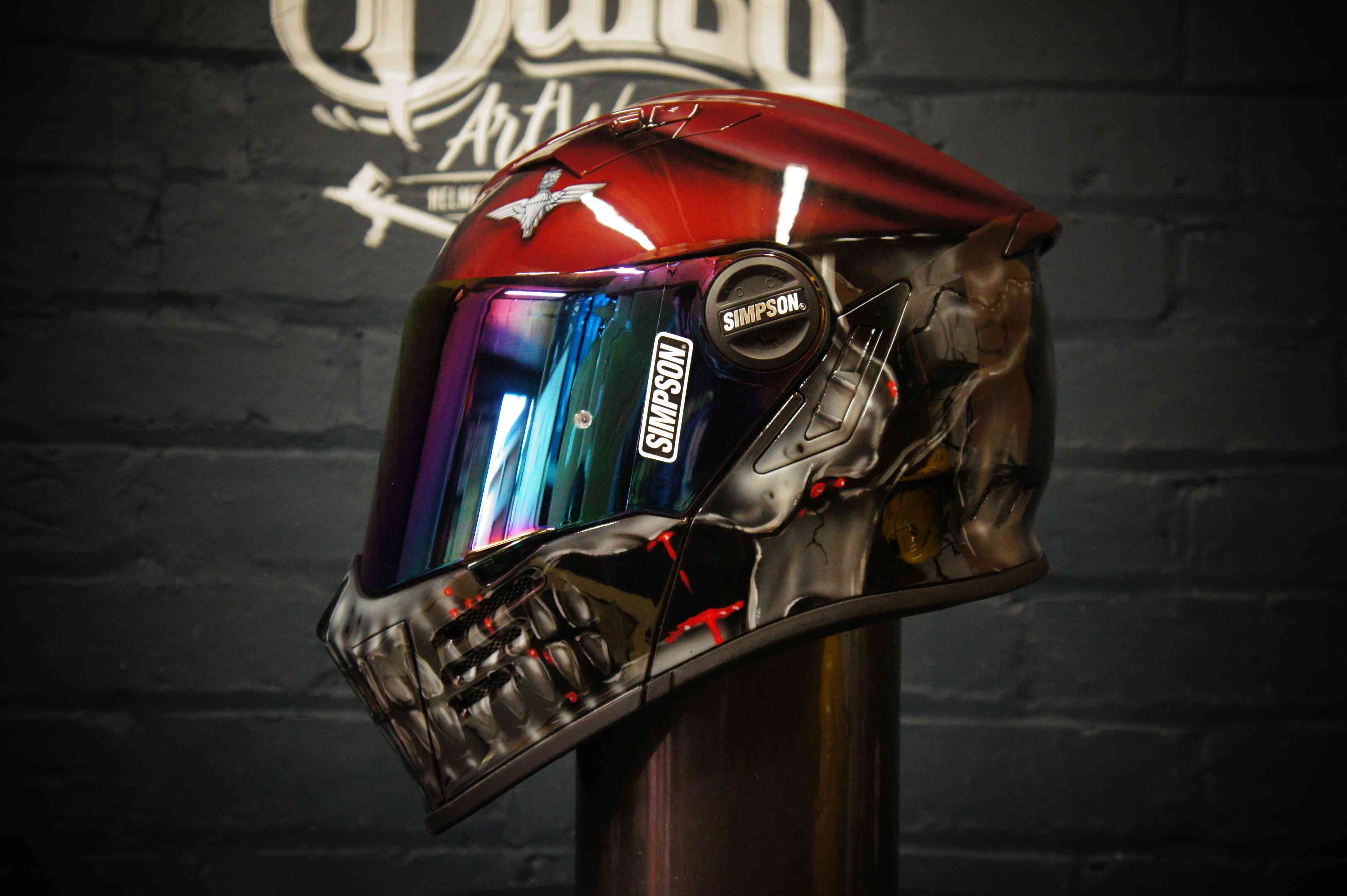 Red Simpson motorcycle helmet with chrome robotic skull design featuring glowing red LED eyes and metallic jaw detail