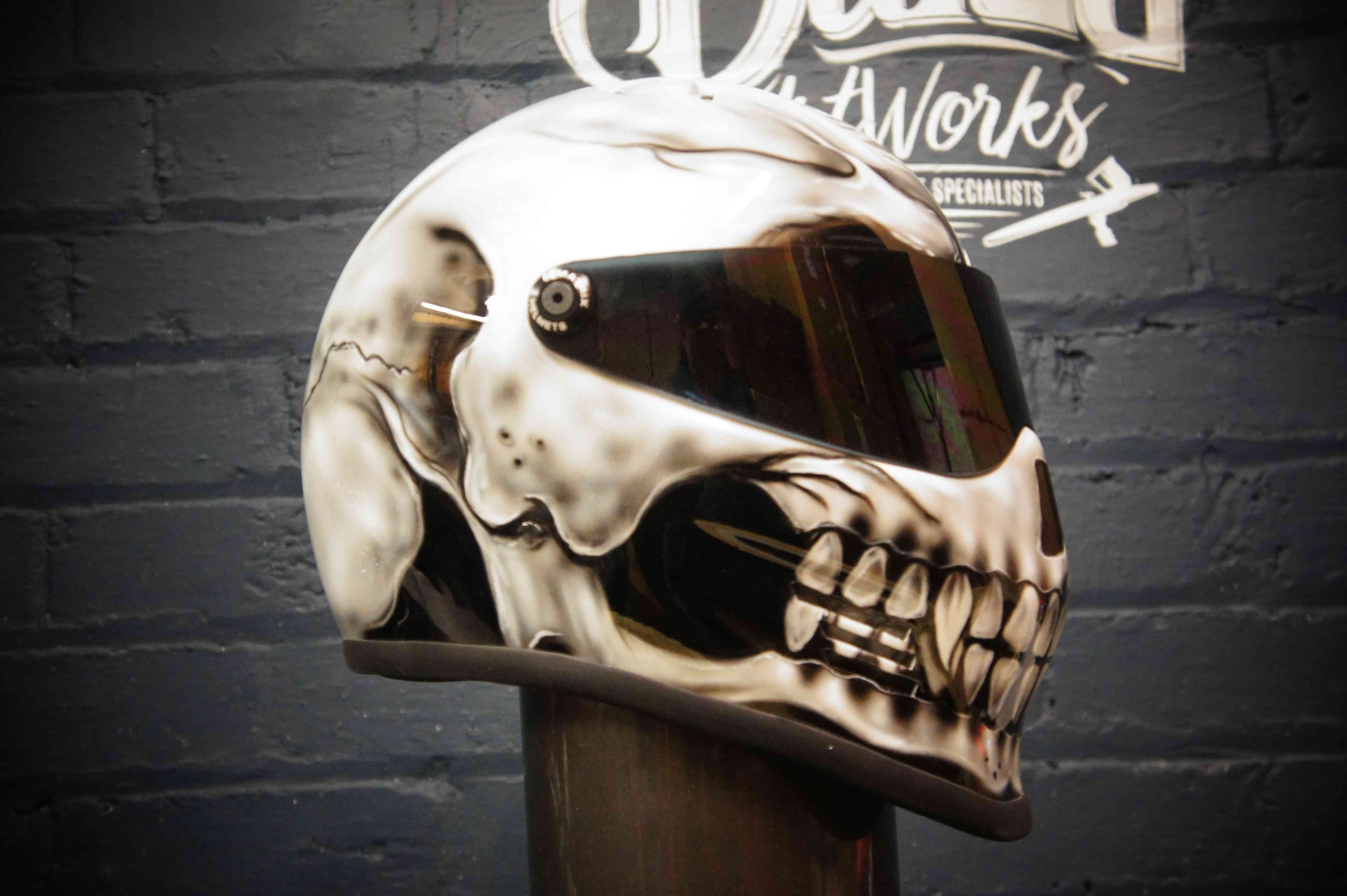 Photorealistic skull motorcycle helmet with cream and brown anatomical details, dark tinted visor, professional airbrush finish