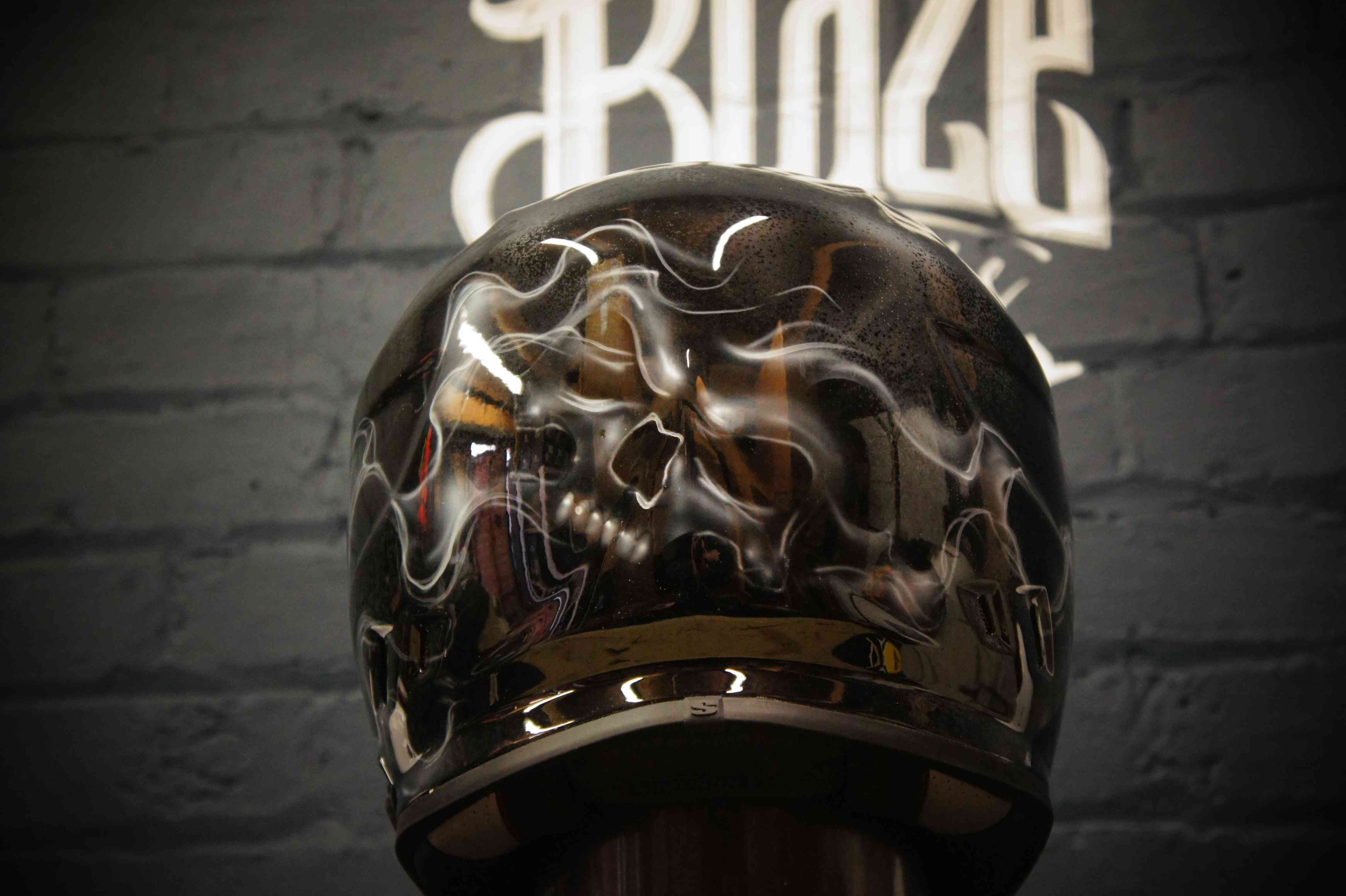Black motorcycle helmet with chrome reflective skull design, distorted metallic finish with glossy clear coat