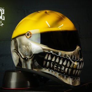 Yellow motorcycle helmet with detailed black and white grim reaper skull design featuring skeletal jaw and teeth detail