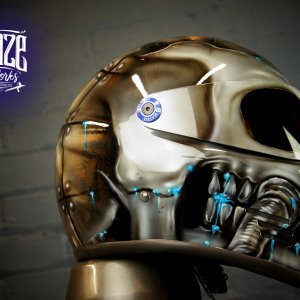 Chrome mechanical skull motorcycle helmet with metallic silver finish, blue accent lights, robotic jaw detail and futuristic design