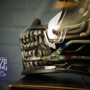 Detailed chrome skull design airbrushed on motorcycle helmet with metallic silver finish, realistic bone texture and jaw detail