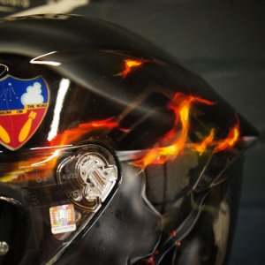 Black motorcycle helmet with realistic orange and red flame design, tribal flame pattern with candy finish and airbrush detail