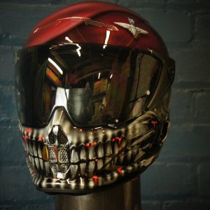 Red and black motorcycle helmet with detailed skeletal jaw design, white teeth, red LED accents, dark reflective visor