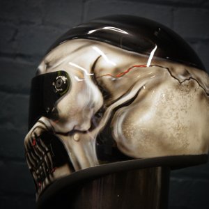 Black motorcycle helmet with highly detailed photorealistic grey skull design featuring anatomical bone structure and gothic horror elements