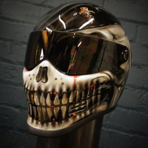 Black motorcycle helmet with realistic airbrrushed skull jaw design featuring white bone teeth, dark eye sockets and gothic horror styling