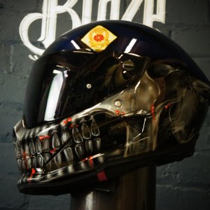 Black motorcycle helmet with metallic chrome skull face design featuring detailed bone structure and red accent lighting