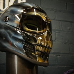 Chrome skull helmet with menacing teeth design, dark metallic finish, gothic horror style custom motorcycle helmet artwork