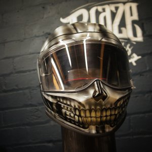 Chrome silver motorcycle helmet with realistic skull jaw design, metallic finish, clear visor, death head airbrushed artwork
