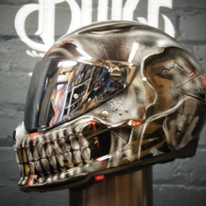 Chrome finish motorcycle helmet with hyper-realistic metallic skull design featuring detailed jaw and teeth in silver tones