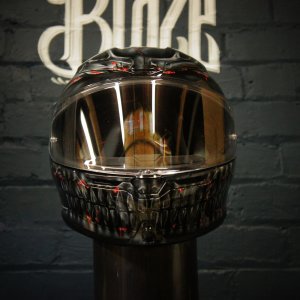 Black motorcycle helmet with detailed grey skull and skeleton jaw design, red accent details, glossy clear coat finish