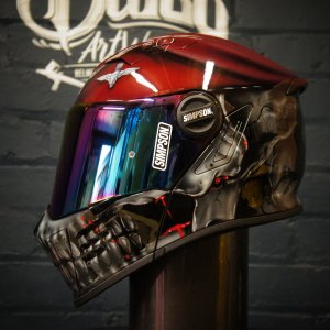 Red Simpson motorcycle helmet with chrome robotic skull design featuring glowing red LED eyes and metallic jaw detail