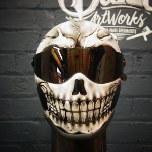 White motorcycle helmet painted with realistic grinning skull design featuring detailed teeth and bone shading effects
