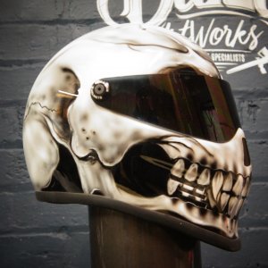 Photorealistic skull motorcycle helmet with cream and brown anatomical details, dark tinted visor, professional airbrush finish
