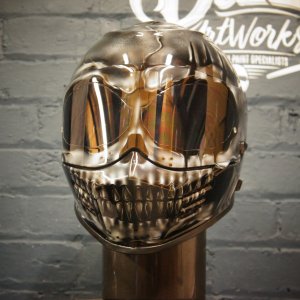 Metallic chrome skull helmet with mirror finish showing anatomical skull design, reflective eye sockets and detailed teeth