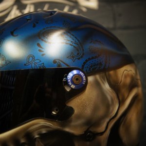 Blue metallic motorcycle helmet with intricate paisley bandana pattern in darker blue tones, featuring teardrop and swirl motifs