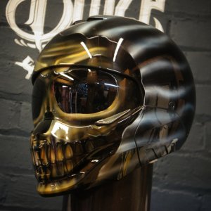 Glossy chrome skull motorcycle helmet with metallic finish, realistic bone structure, hollow eye sockets, detailed teeth
